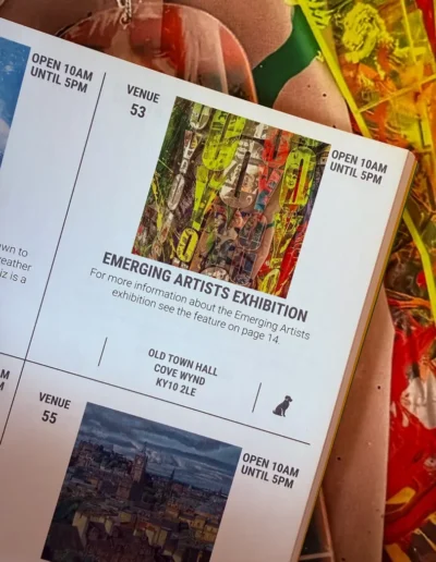 Pittenweem Arts Festival exhibition leaflet displayed over colourful textile artwork